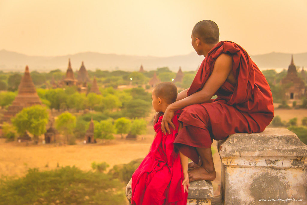 2 monks watch the sun set over dozens of temples in Bagan