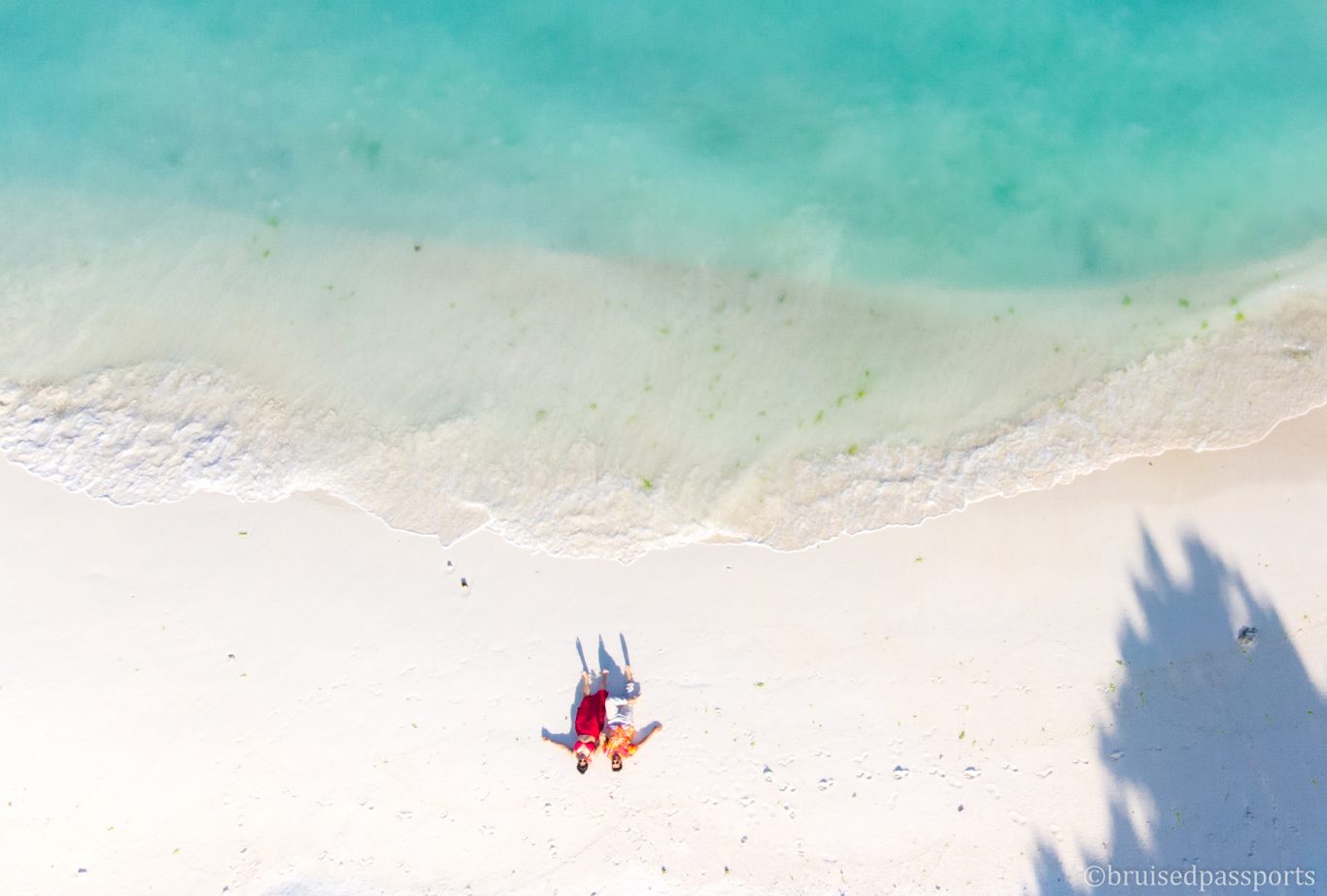 drone shot of couple lying on the beach in MAldives