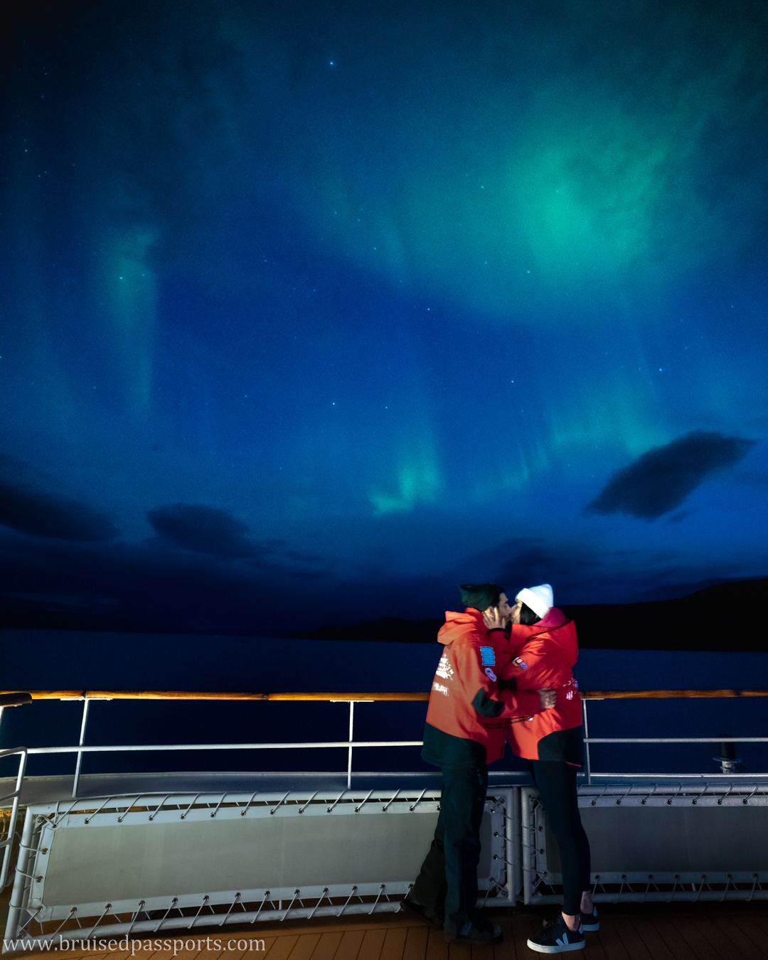 couple under northern lights in greenland canada on a cruise ship 